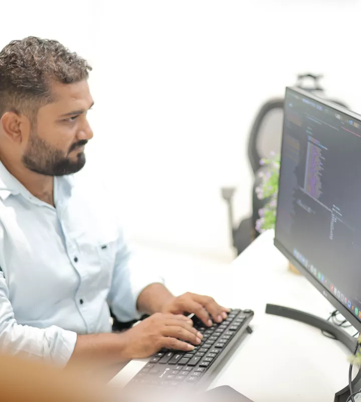 Engineer reviewing code on a monitor