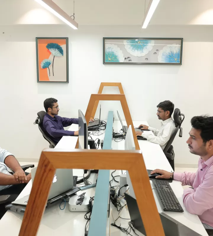 Engineers working at shared desks on the development floor